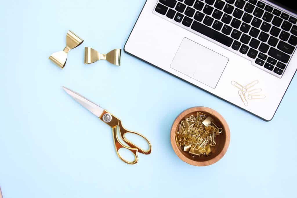 Laptop with paperclips and scissors