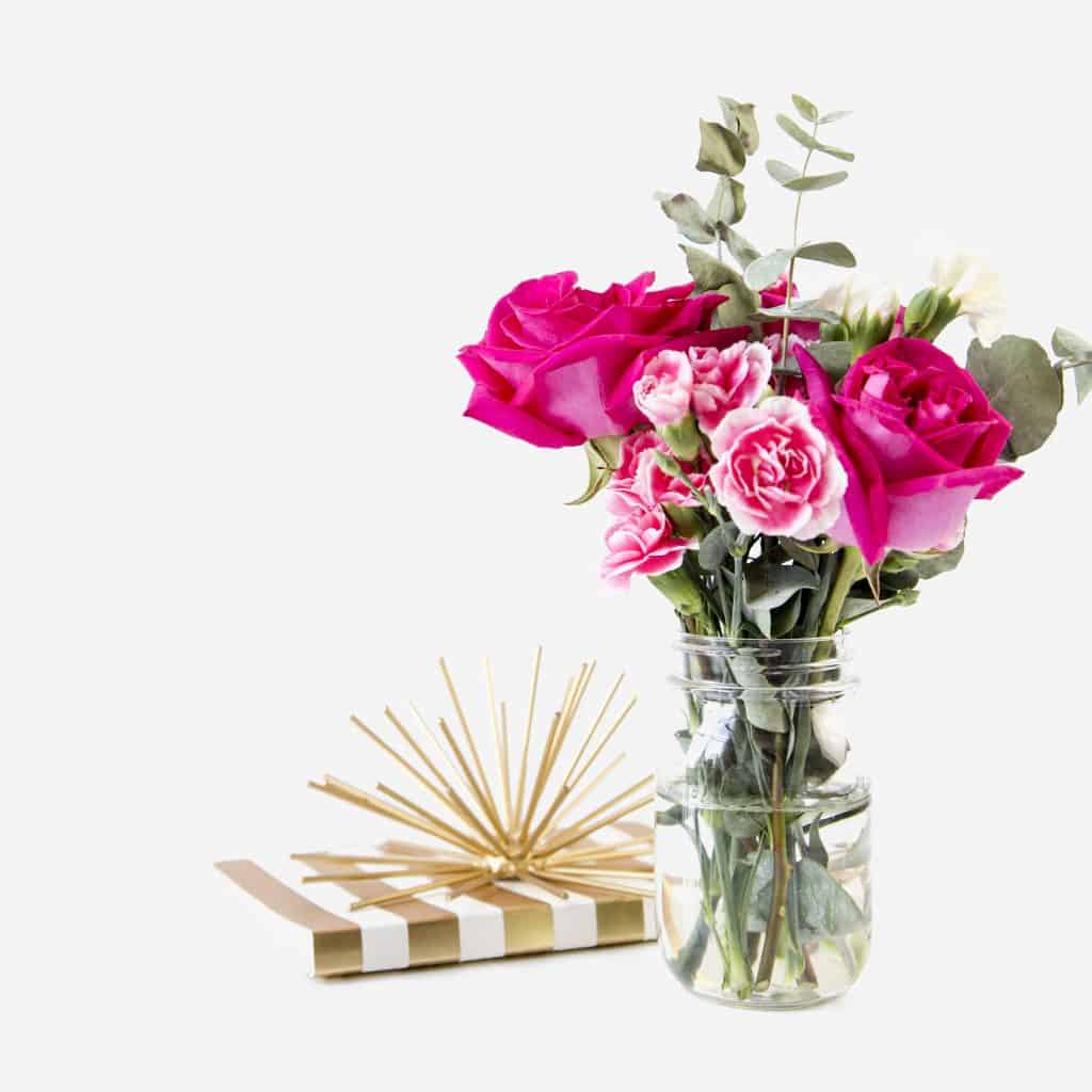 Bouquet of flowers in vase with journal and sculpture