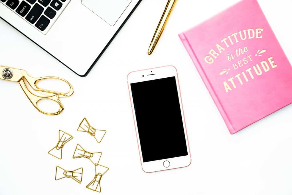 Flatlay image with notebook, smartphone, clips, scissors and laptop