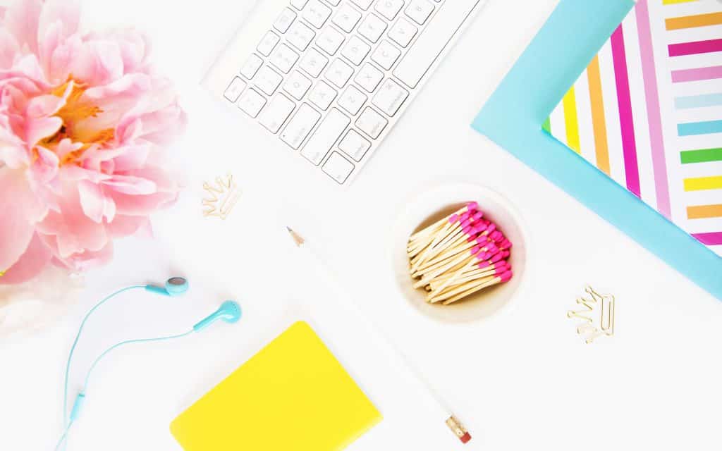White keyboard, journals, matches in dish and peony
