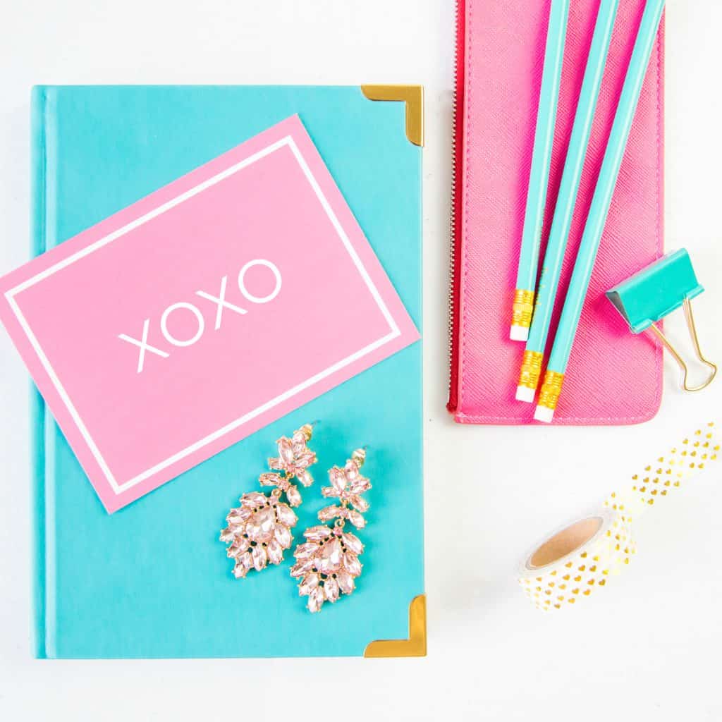 Flatlay with folder, notecard, pencils and earrings