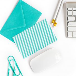 envelope, notecard, pencils and laptop