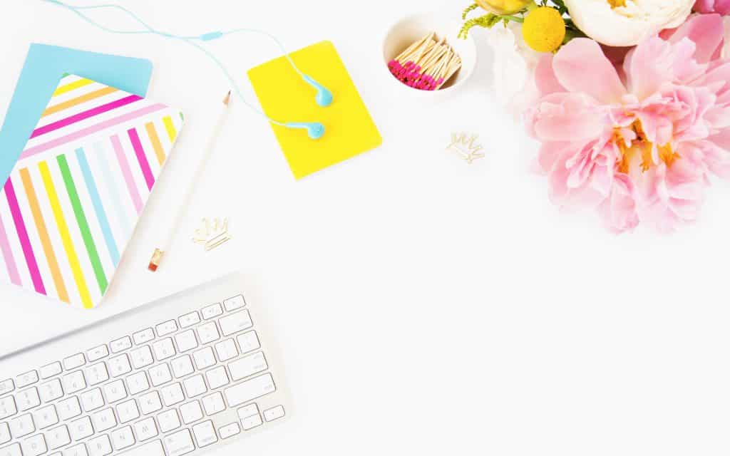 laptop, journals, earbuds, pushpins, matches in dish and flower