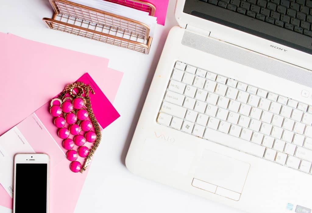 laptop with paper, breacelet, and smartphone