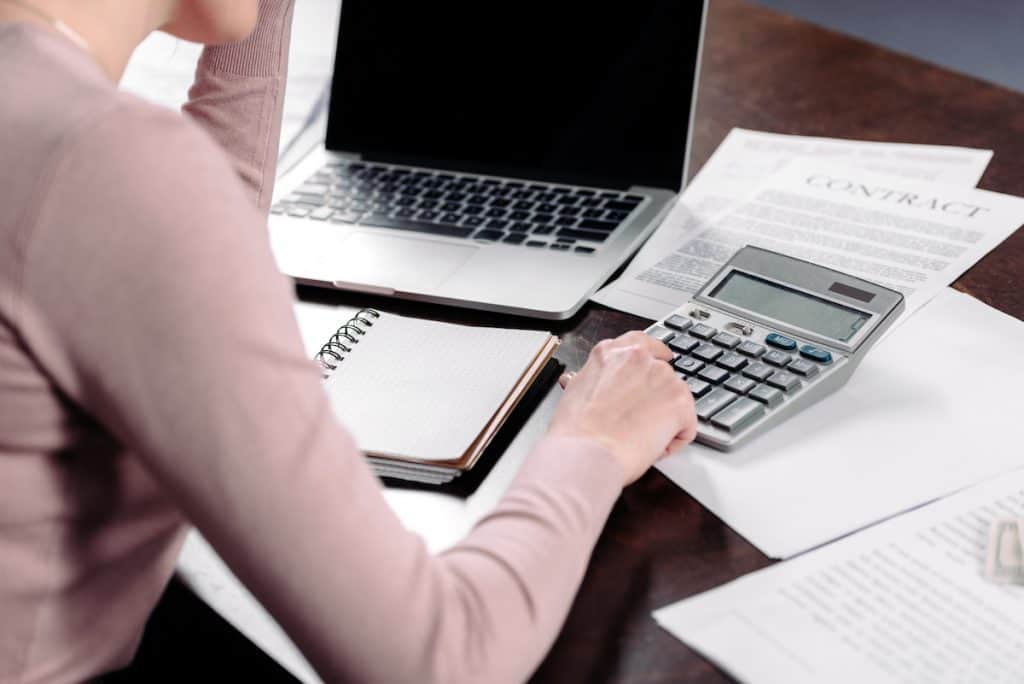 woman sitting at desk using a calculator