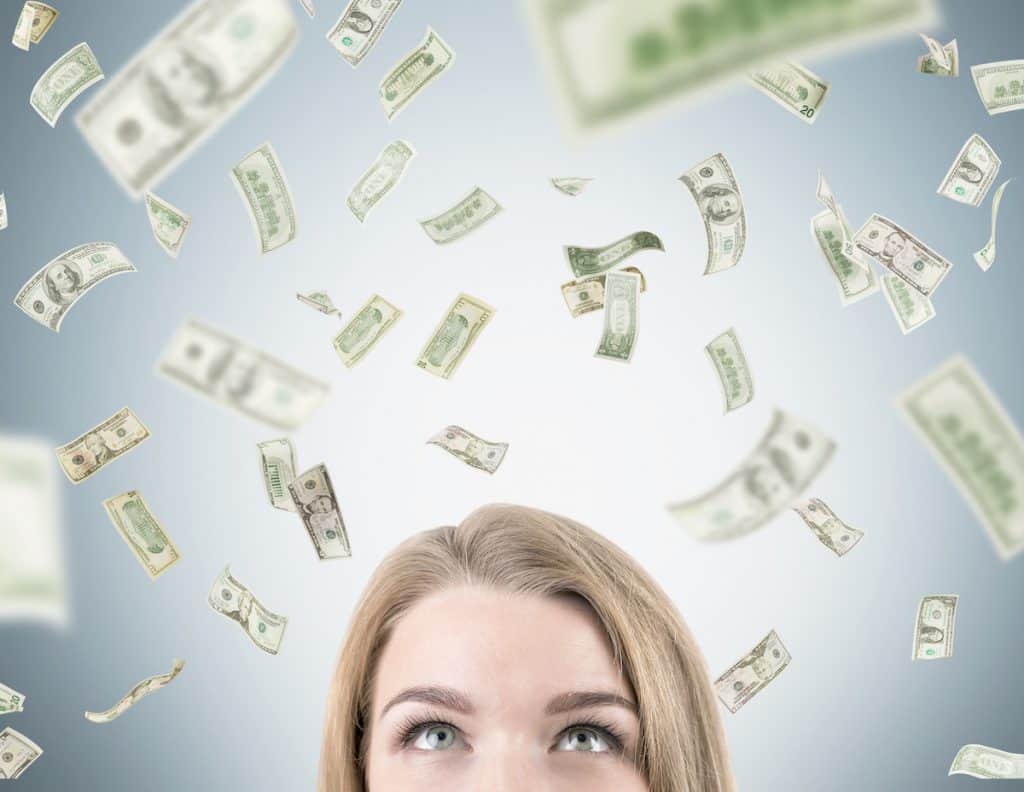 Image of woman's head with cash floating around her