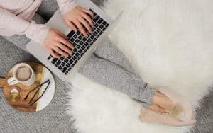 woman with laptop on her lap typing