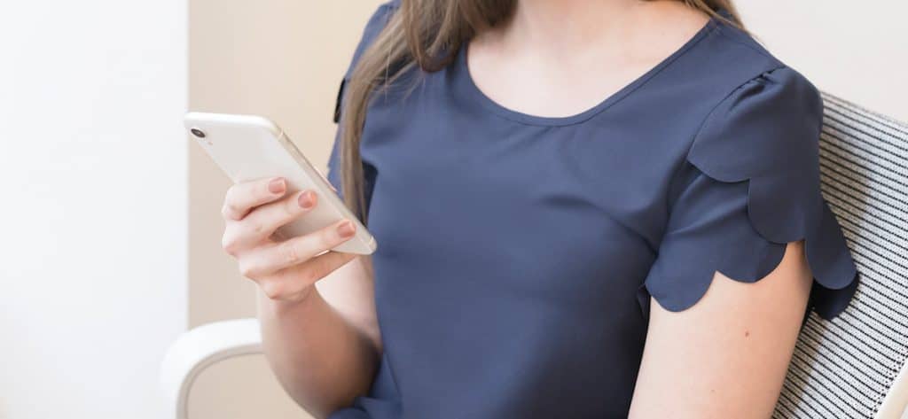 woman on phone with information about how to get paid to test apps and sites