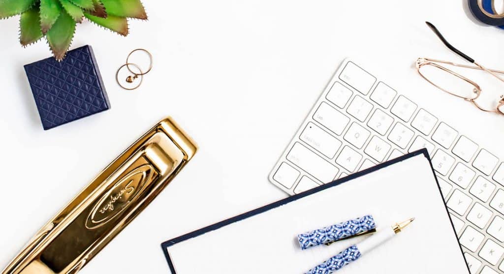 keyboard, notebook, pens, stapler ad plant