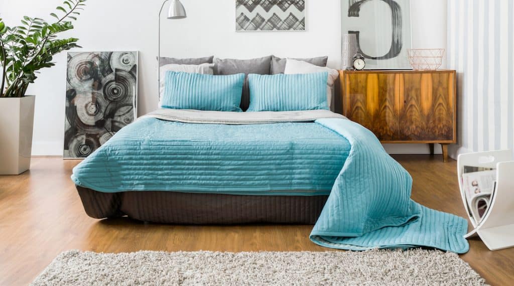image of a beautiful blue bed used as the featured image for the post on how to become an airbnb host