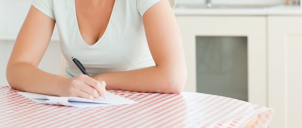 woman sitting at table proofreading papers