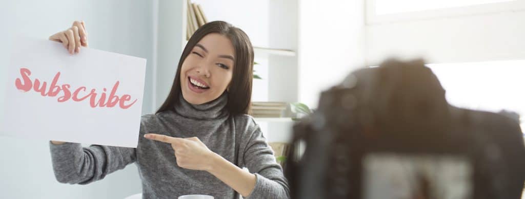 woman holding a sign with text subscribe