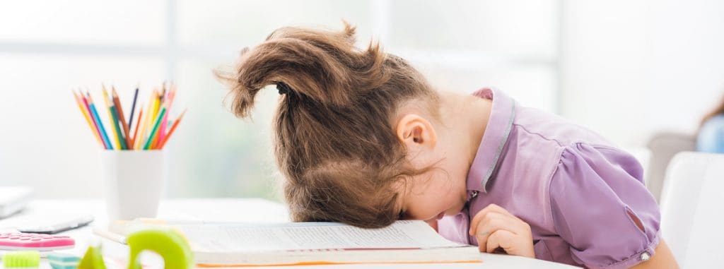 Girl with head down on desk bored
