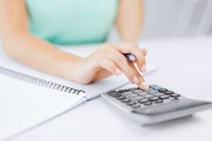 female bookkeeper typing on calculator