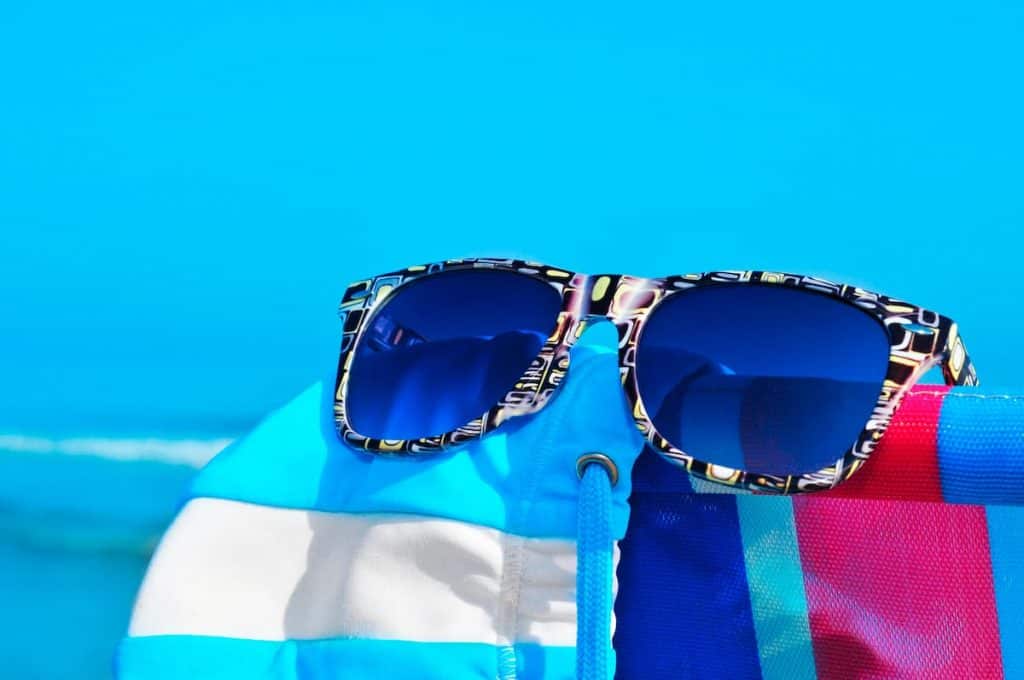 Pair of knock of Ray-Ban sunglasses on the beach.